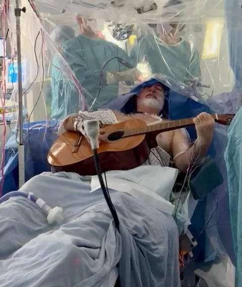 Watch the moment man plays guitar while having brain surgery to remove golf ball-sized tumour  The Sun [Video]